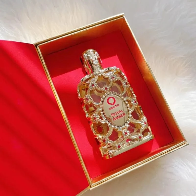 Orientica Royal Amber · Eau de Parfum 80 ml · Unisex — el frasco fotografiado en una escena de ambiente